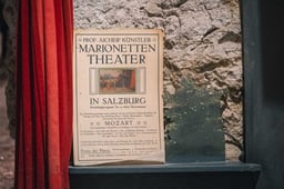 Historic poster for Professor Aicher Marionettentheater in Salzburg displayed at the Marionette Museum.