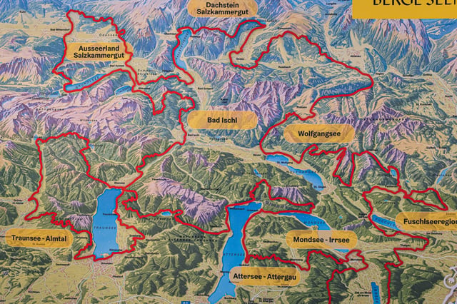 A painted panorama map board of the Salzkammergut, its tourism regions outlined in red, with the Bad Ischl label at the centre among the lakes and mountains.