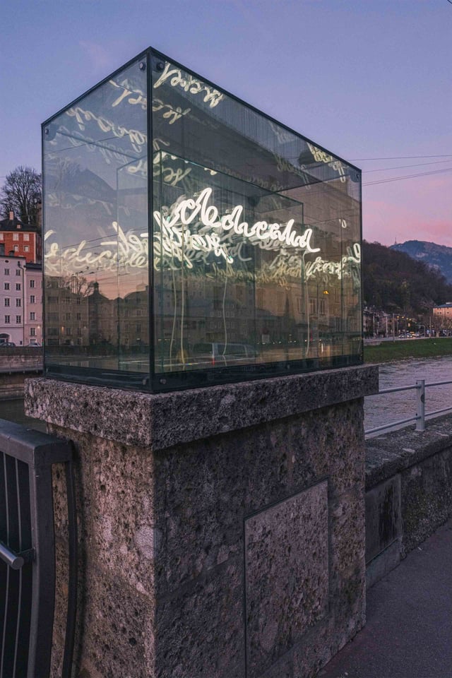 Beyond Recall illuminated vitrine in context along the Salzach in Salzburg, part of the Walk of Modern Art