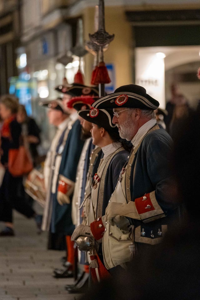 Salzburg Buergergarde members lined up in 18th-century uniforms with tricorn hats and ceremonial weapons