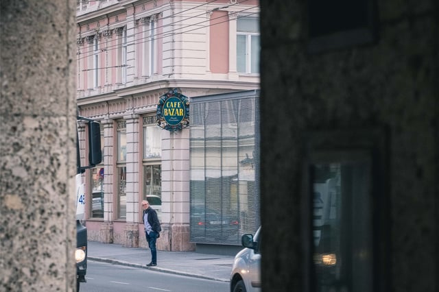 Cafe Bazar sign and facade glimpsed across Schwarzstrasse in Salzburg Neustadt.