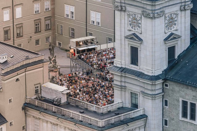 Audience seated before the Jedermann stage on Domplatz beside the cathedral in Salzburg.