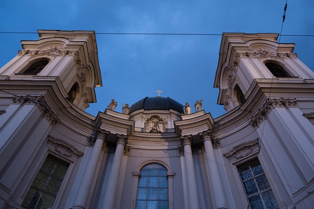 Baroque twin tower facade of Dreifaltigkeitskirche at dusk in Salzburg