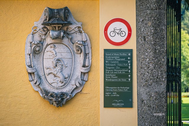 Hellbrunn coat of arms and park signage board at Schloss Hellbrunn gate near Salzburg.
