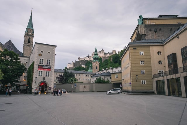 Open square in front of Festspielhaus with Michaelskirche spire and Hohensalzburg fortress behind
