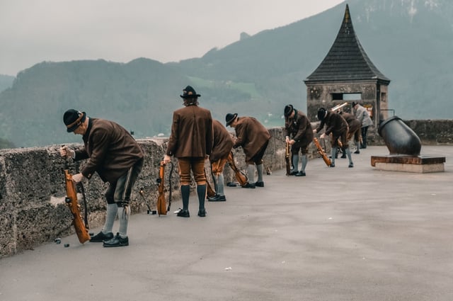 Line of Prangerschuetzen marksmen preparing ceremonial guns on the fortress battlement in Salzburg