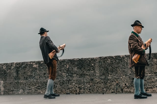 Two traditionally dressed marksmen load ceremonial guns on the Hohensalzburg fortress rampart in Salzburg