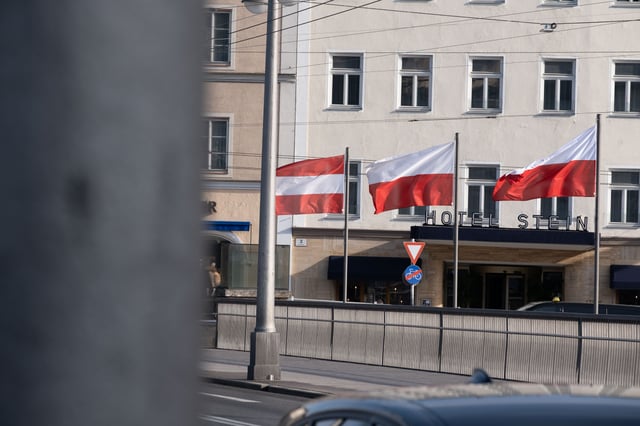 Three flags fly outside the Hotel Stein entrance across the street in Salzburg.