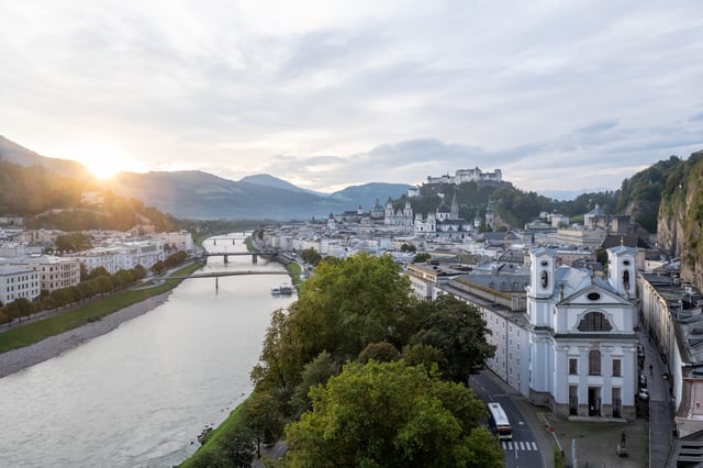 View from Humboldtterrasse at dawn with Salzach River old town fortress and Dreifaltigkeitskirche in Salzburg.