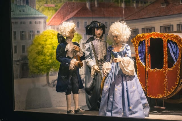 Baroque marionette figures and carriage displayed at the Marionette Museum inside Hohensalzburg in Salzburg.