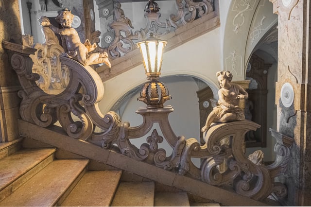Ornate Donner Stiege with cherub sculptures and lantern inside Mirabell Palace in Salzburg