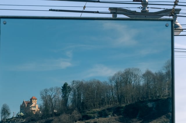 Reflection in a polished panel shows Schloss Edmundsburg perched atop the Moenchsberg cliff in Salzburg.