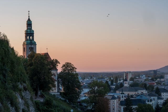 Mülln Church with green onion dome tower at sunset seen from Mönchsberg in Salzburg