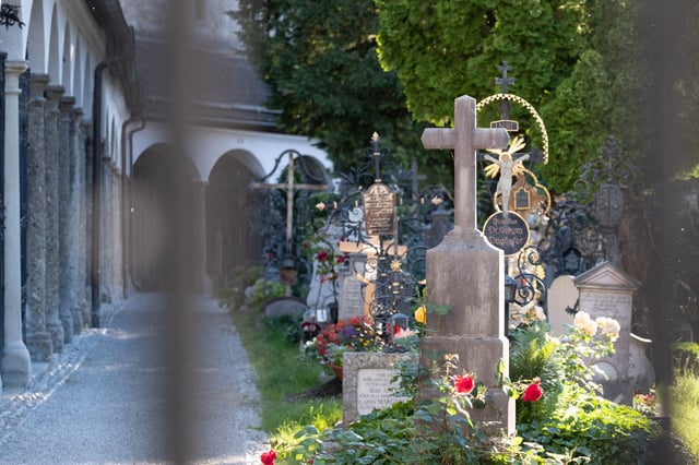 Baroque wrought-iron grave crosses and arcaded tombs at Petersfriedhof cemetery in Salzburg