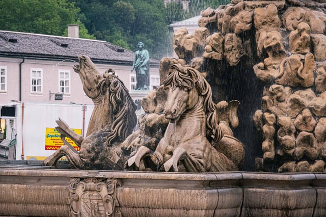 Rearing horses and tritons with water jets on the Residenzbrunnen fountain in Salzburg old town
