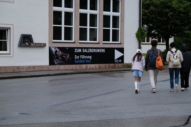 Visitors walk toward the guided-tour entrance sign of the Salzbergwerk in Berchtesgaden