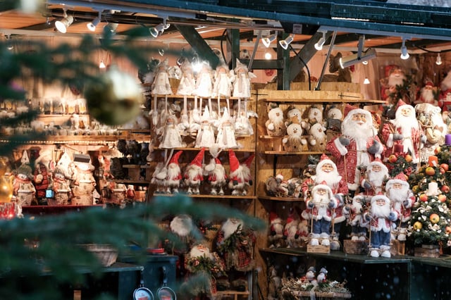 Christmas market stall lined with Santa figurines at the Salzburg Christkindlmarkt.