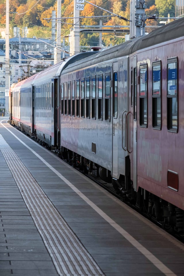Long red and white intercity train standing at a platform at Salzburg Hauptbahnhof.