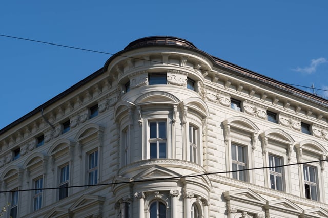 Ornate cream Gründerzeit corner building facade with stucco reliefs in Salzburg Neustadt