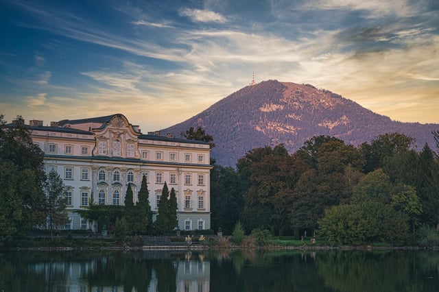 Schloss Leopoldskron reflected in pond with Gaisberg mountain behind at sunset near Salzburg