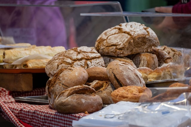 Rustic sourdough loaves stacked on a red gingham cloth at the Schrannenmarkt farmers market in Salzburg