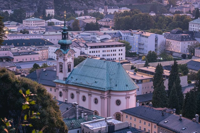 Close-up of Sebastianskirche green-domed church tower above Neustadt at dusk in Salzburg