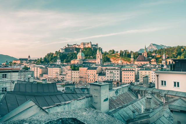 Rooftop view over Salzburg Neustadt with Sebastianskirche tower and distant mountains