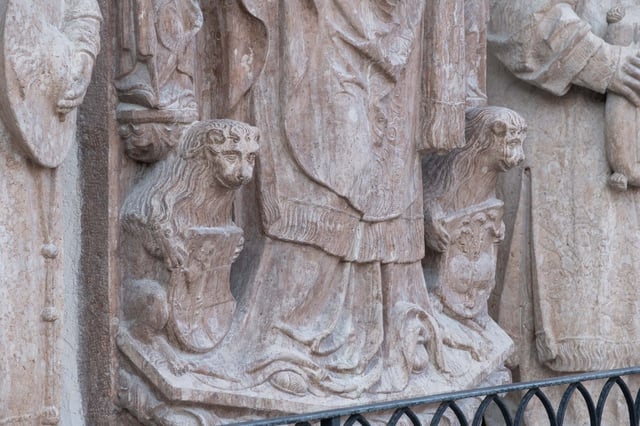 Carved Romanesque lion at the base of a portal supporting a saint figure at St Georges Chapel inside Hohensalzburg Fortress in Salzburg
