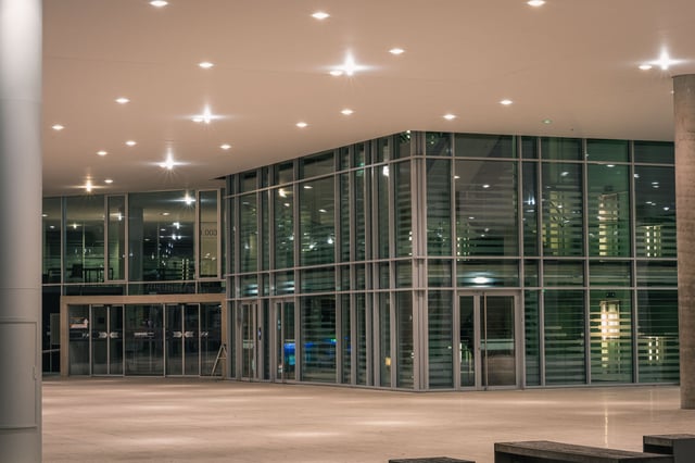 Unipark Nonntal building lit at night with glass facade in Salzburg