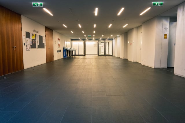 Empty modern foyer interior of the Universitaet Mozarteum performance building with glossy floor and exit signs in Salzburg