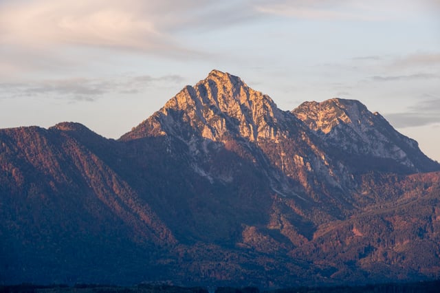 Untersberg massif glowing in warm morning light with forested foothills below near Salzburg.