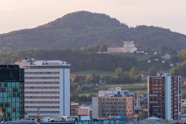 Maria Plain pilgrimage church on hill above modern apartment blocks in Salzburg.